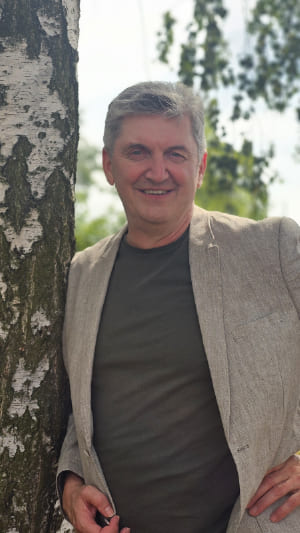 Coach André Fischer lehnt an einem Baum